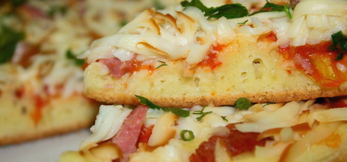Пицца с колбасой, сыром и помидорами на сковороде