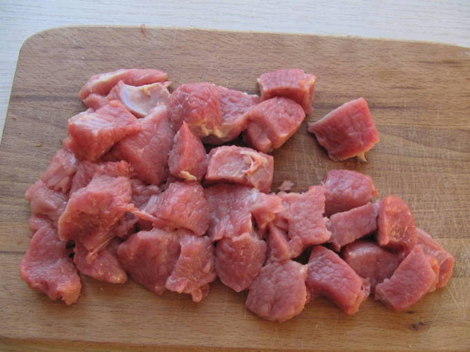 Гуляш из свинины с подливкой из томатной пасты, моркови и лука на сковороде