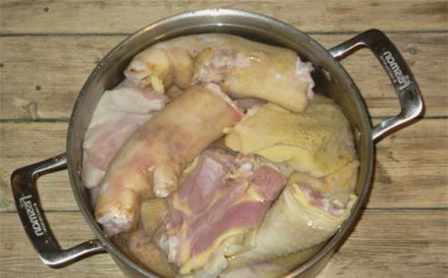 Холодец из свиных ножек и курицы в кастрюле