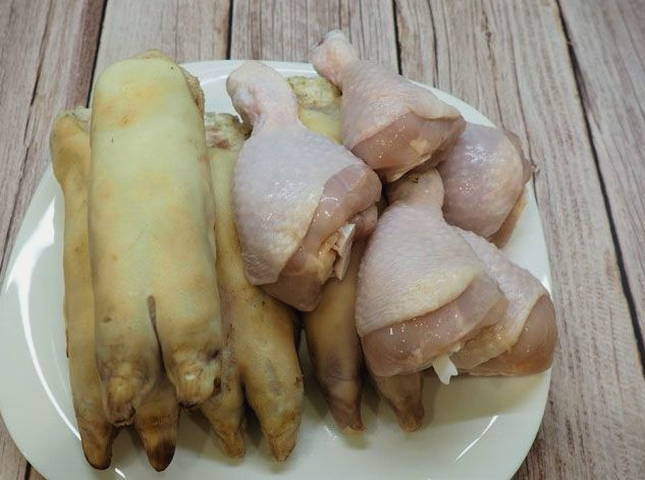 Холодец из свиных ножек, рульки и курицы в кастрюле