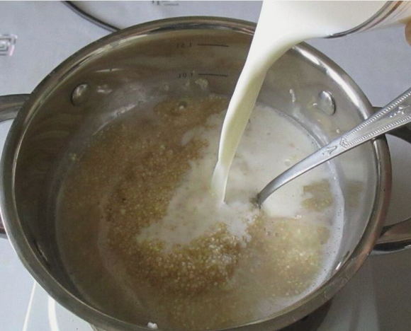 Ячневая каша на молоке в кастрюле на плите