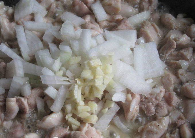 Рассыпчатый плов с рисом, курицей и морковью в кастрюле на плите