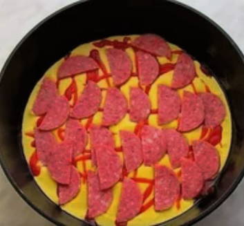 Пицца с яйцом, колбасой и сыром и помидорами на сковороде