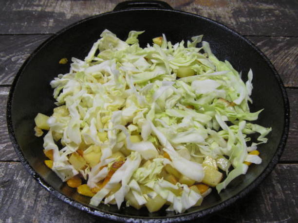 Тушеная капуста с картошкой и сосисками на сковороде