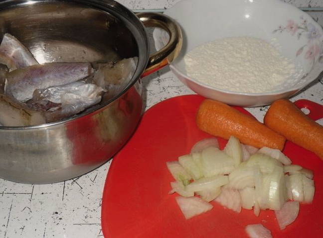 Жареный минтай с луком, морковью и майонезом на сковороде
