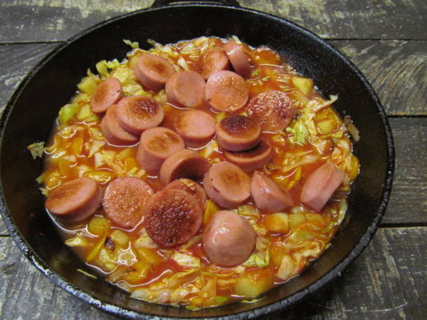Тушеная капуста с картошкой и сосисками на сковороде