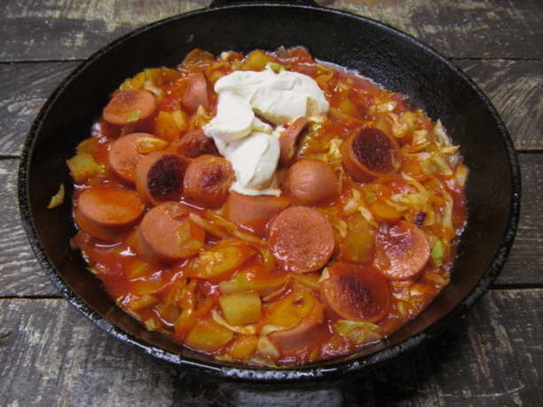 Тушеная капуста с картошкой и сосисками на сковороде