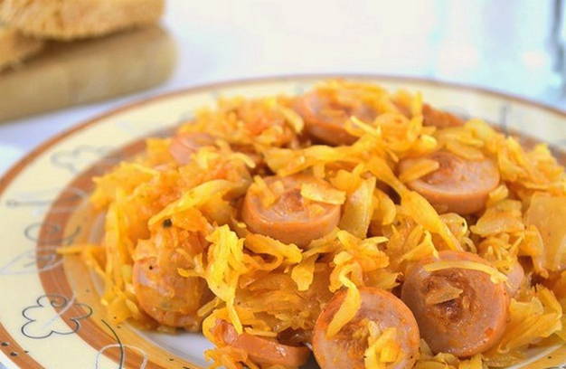 Тушеная капуста с сосисками и томатной пастой в кастрюле