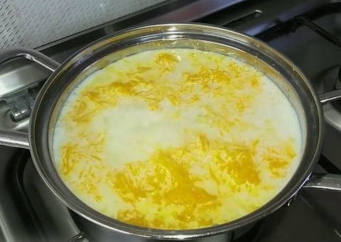 Пшенная каша с тыквой в кастрюле на газовой плите Пшенная каша с тыквой в кастрюле на газовой плите