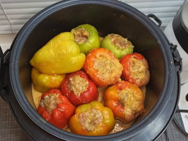 Тушеный фаршированный перец с морковью и луком в кастрюле