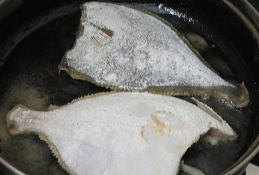 Камбала с луком и морковью на сковороде