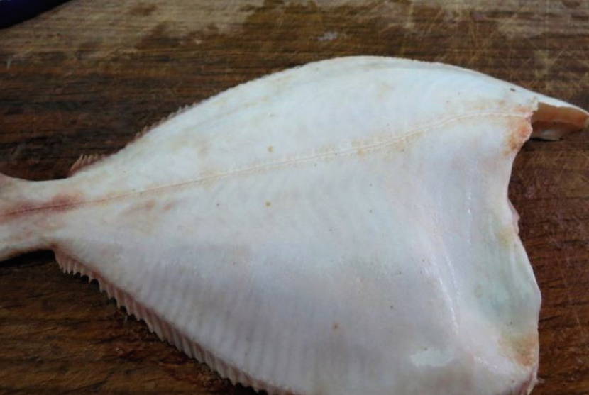 Камбала с луком и морковью на сковороде