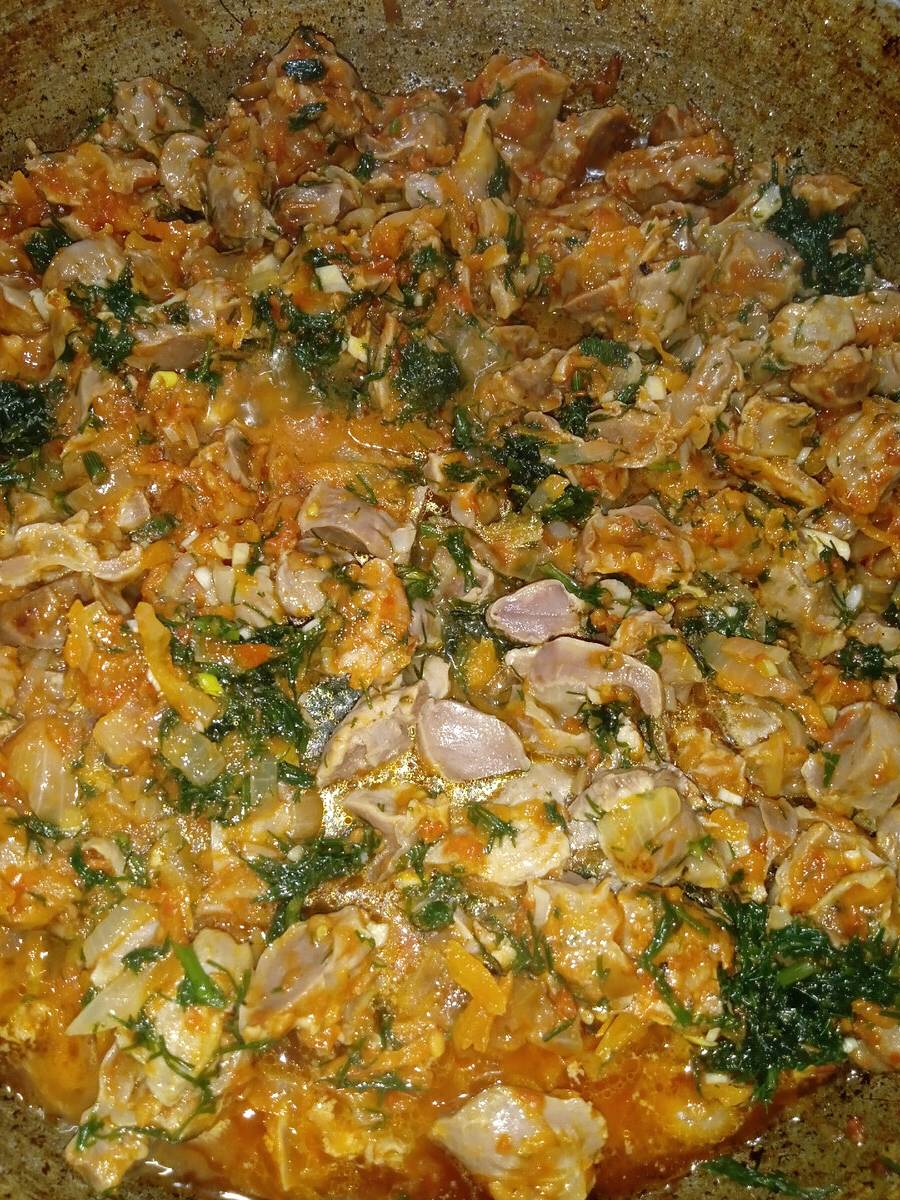 Тушеные куриные желудки с луком и морковью на сковороде
