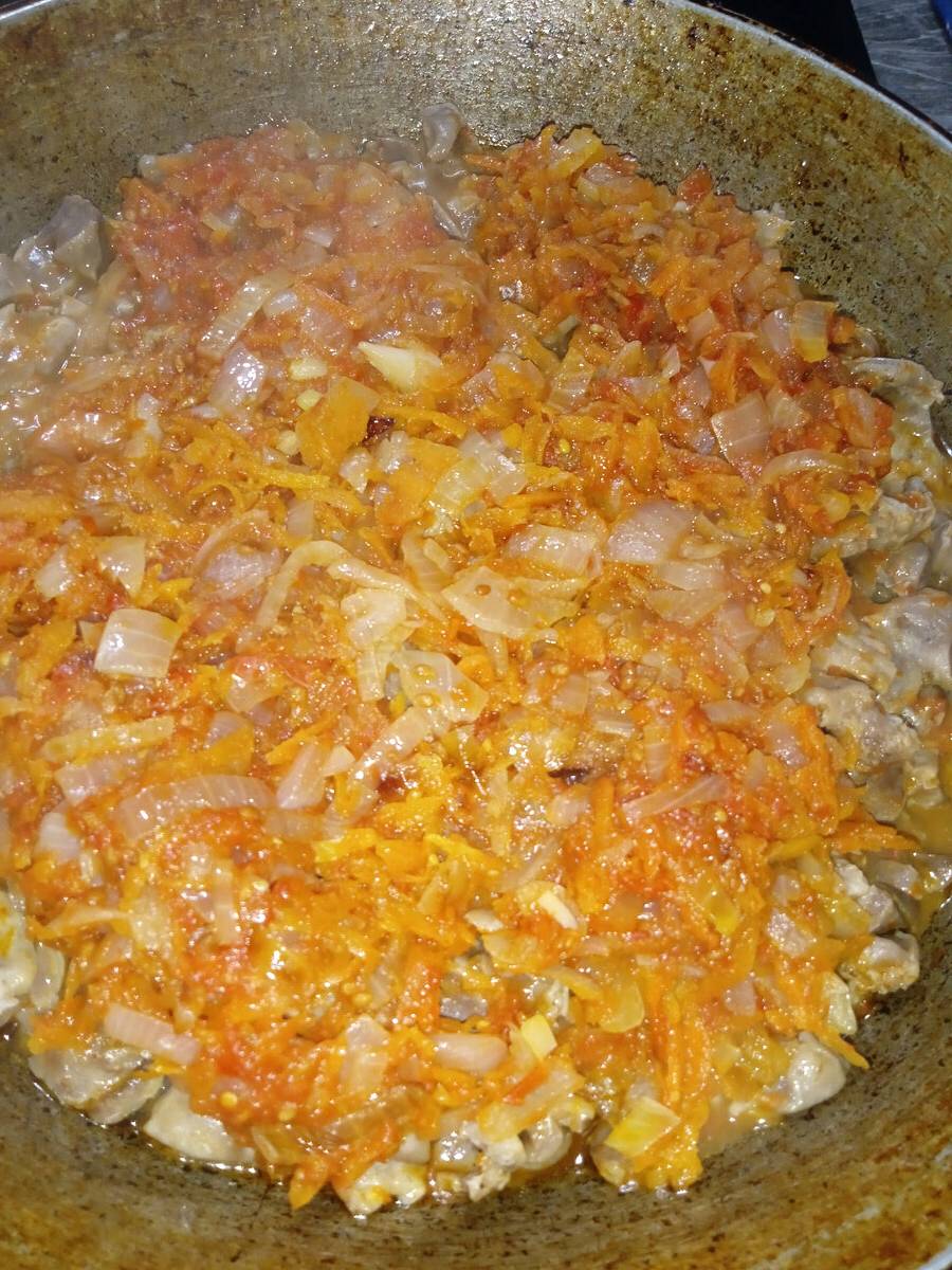 Тушеные куриные желудки с луком и морковью на сковороде