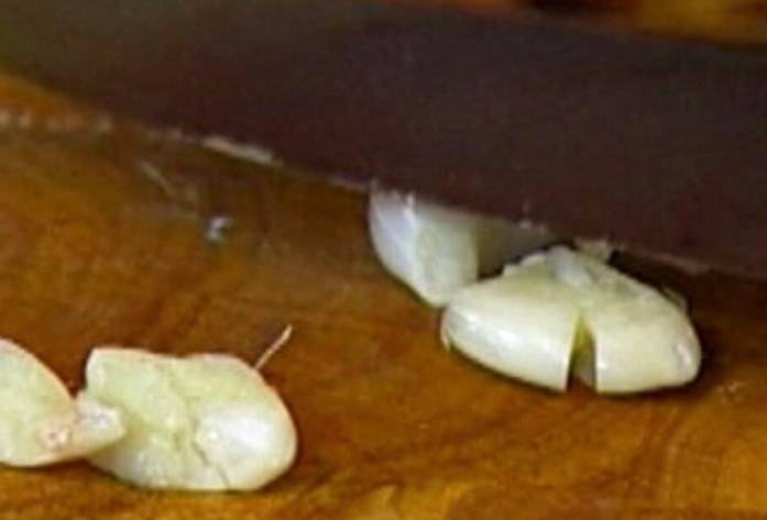 Замороженные неочищенные креветки с чесноком и соевым соусом на сковороде