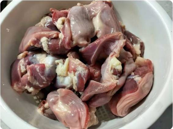 Жареные куриные желудки с луком на сковороде