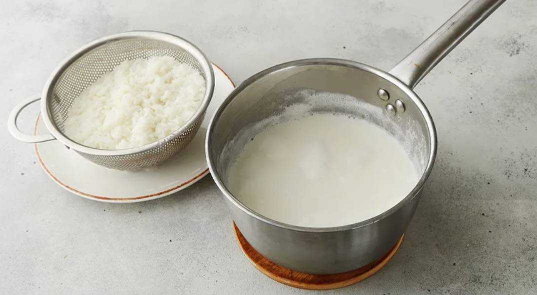 Каша рисовая на молоке в кастрюле на плите