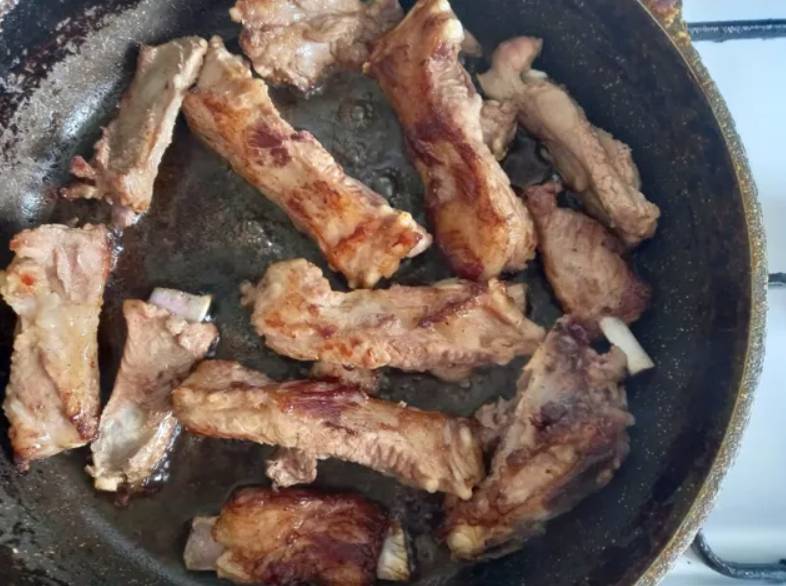 Свиные ребрышки с луком и чесноком на сковороде