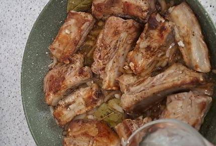 Свиные ребрышки с луком на сковороде