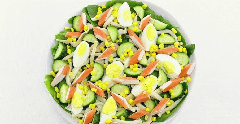 Салат из крабовых палочек, кальмаров, кукурузы, яйца и огурца