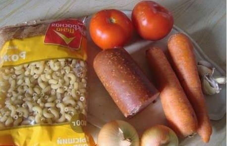 Макароны с колбасой, морковью и луком на сковороде