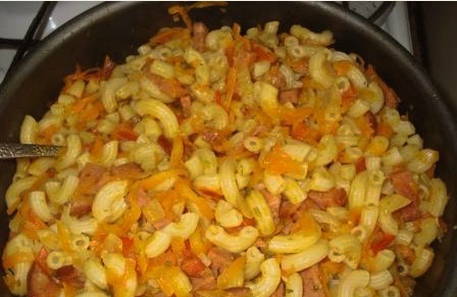 Макароны с колбасой, морковью и луком на сковороде